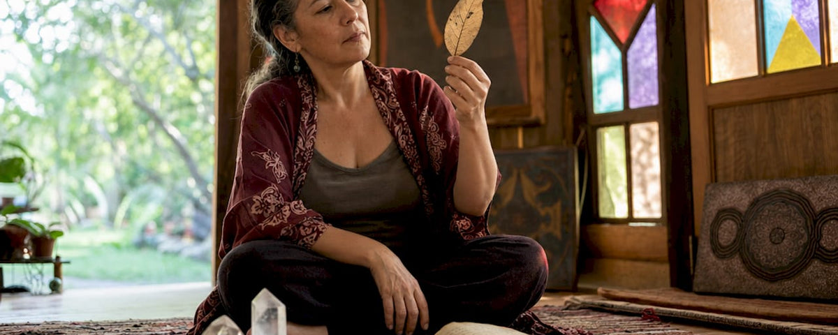 Spiritual healer examining a leaf during assessment