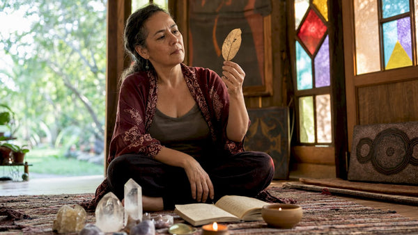 Spiritual healer examining a leaf during assessment