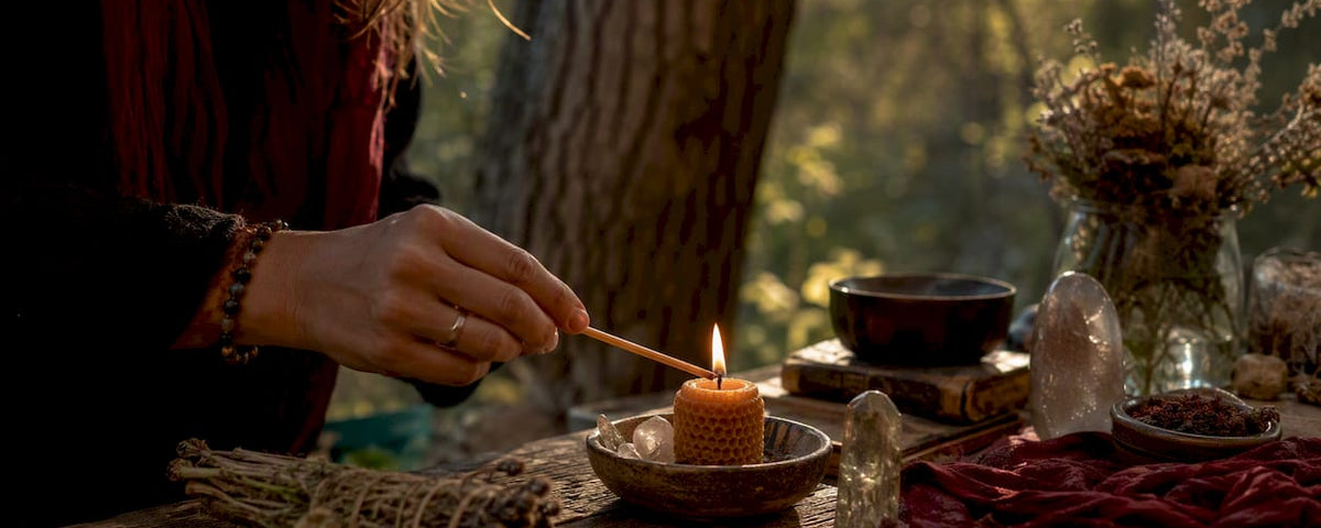 Hands lighting candle on spiritual altar