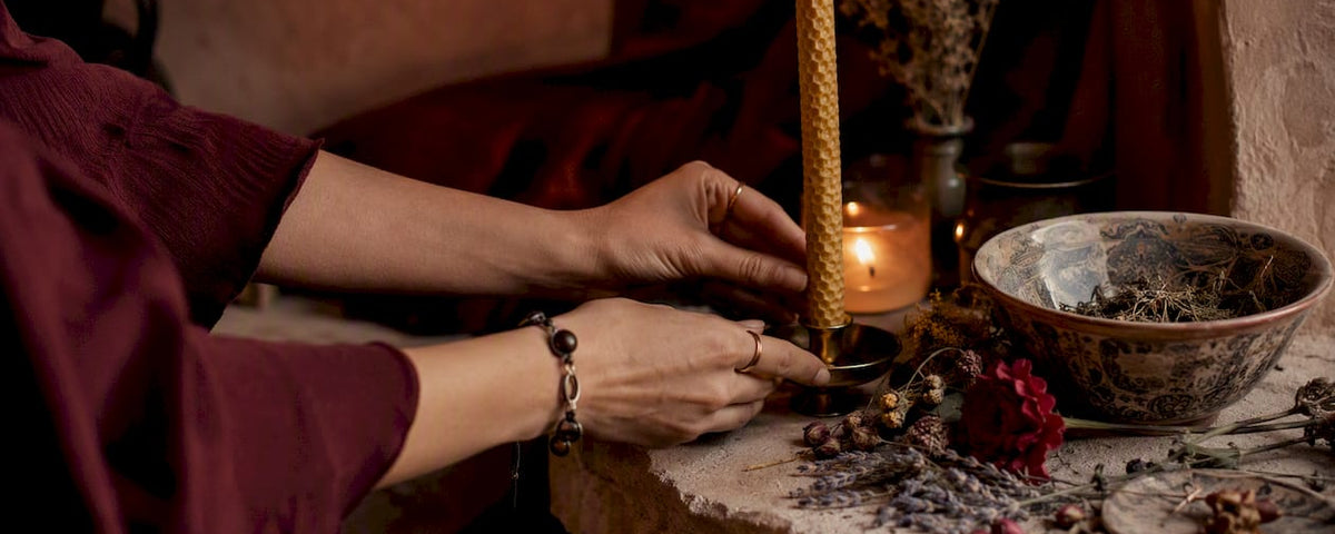 Hands lighting candle on ritual altar