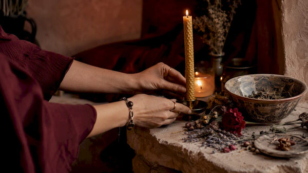 Hands lighting candle on ritual altar