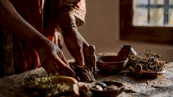 Hands selecting traditional African divination tools