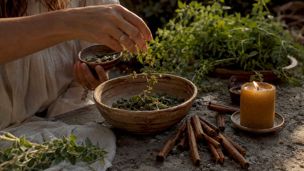 Hands placing coins and bay leaves in money bowl